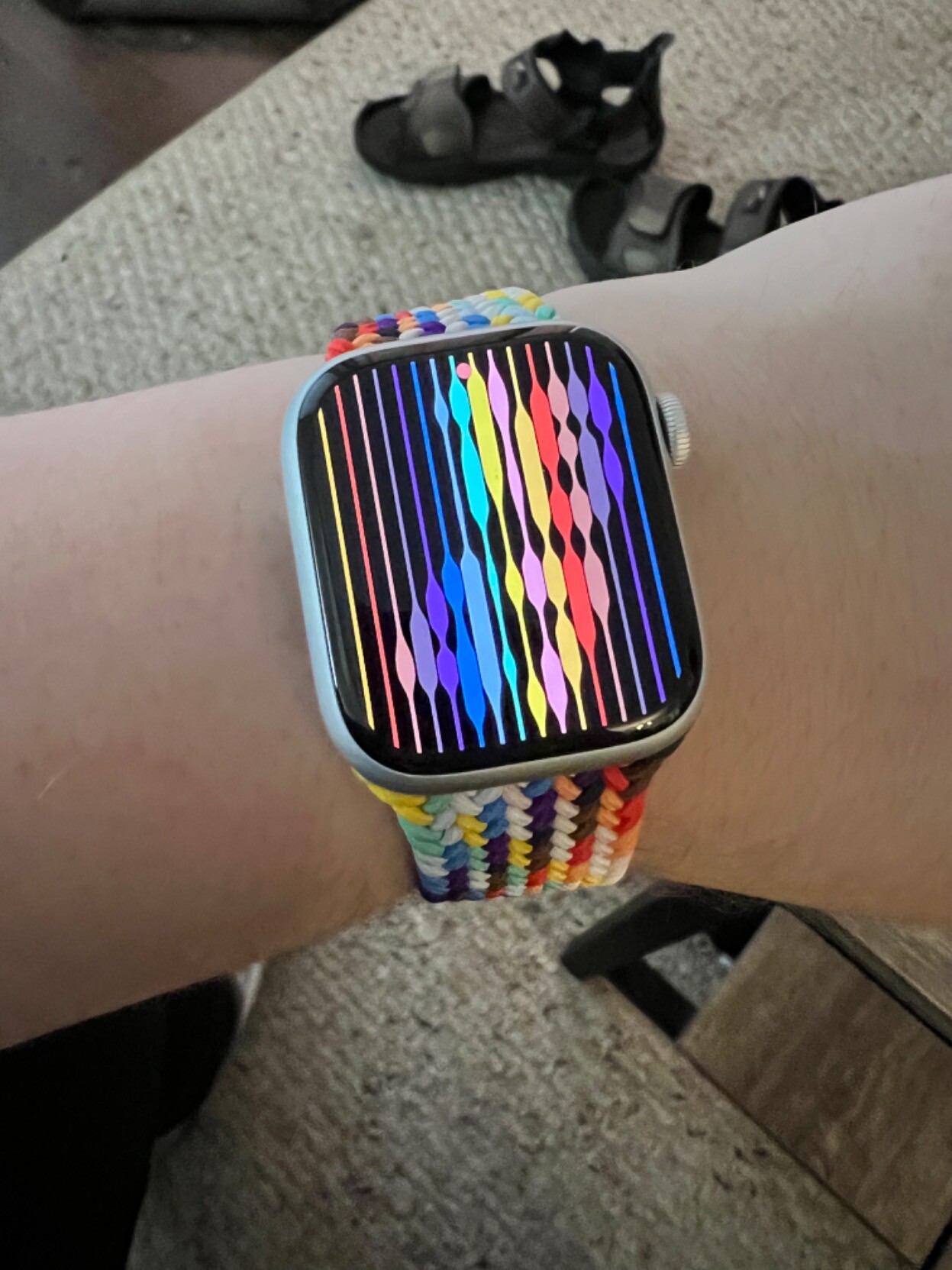 An Apple Watch series 8 with the pride edition band and the time saying "16:47"